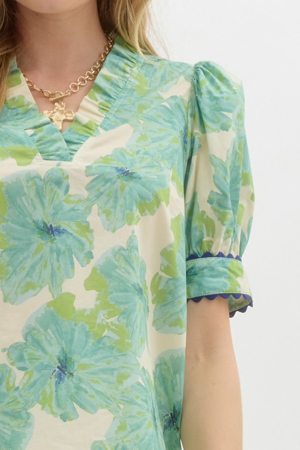 Stylish green floral top with neck and sleeve detail, perfect for coastal boutique clothing and tropical vacation dresses.