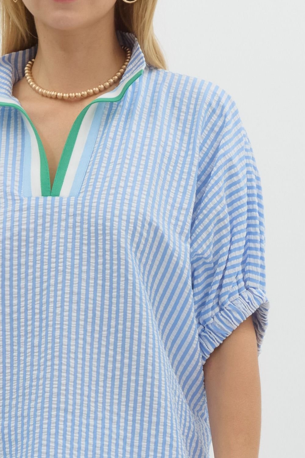 Stylish blue and white striped top with Kelly green detail, perfect for coastal boutique clothing and tropical vacations.