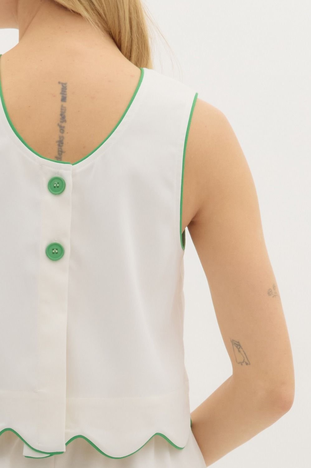 Back view of sleeveless scallop hem top with green trim and button closure, perfect for coastal boutique clothing.
