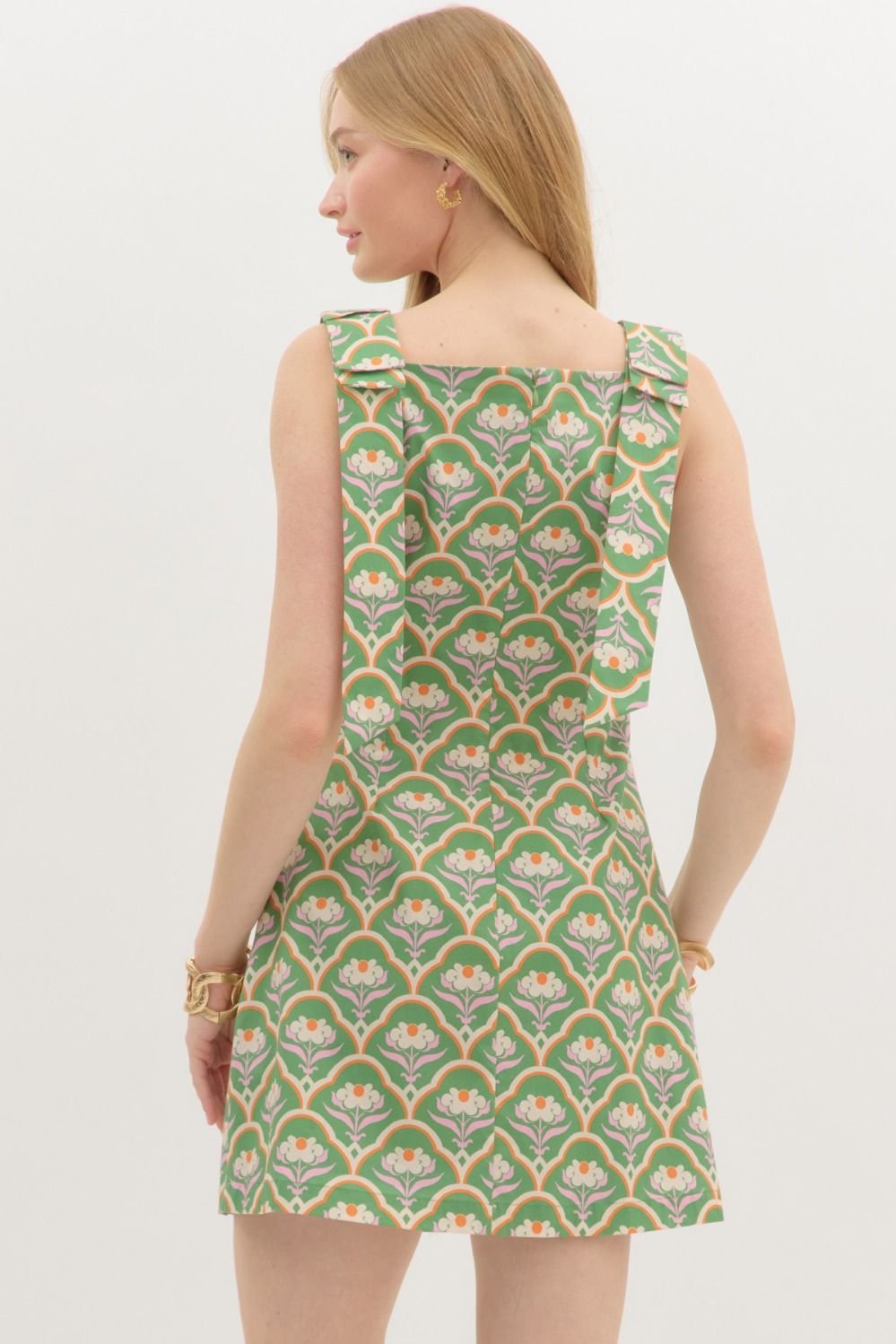 Back view of a green mini dress with floral motifs, perfect for coastal boutique clothing and tropical vacation dresses.