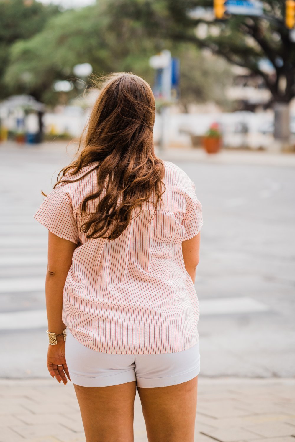 Woman wearing PLUS FAITH TOP RED AND BLUE from Raggdoll Boutique in Port Aransas, showcasing trendy coastal style.
