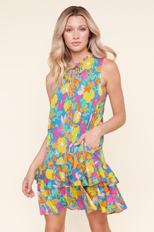 Model wearing GRACELAND FLORAL DRESS from Raggdoll Boutique featuring bright colors and ruffled layers.