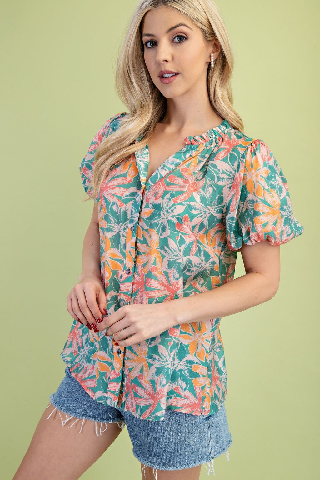 Floral green and orange button down top perfect for spring, available at Port Aransas boutique, ideal for beach outings.