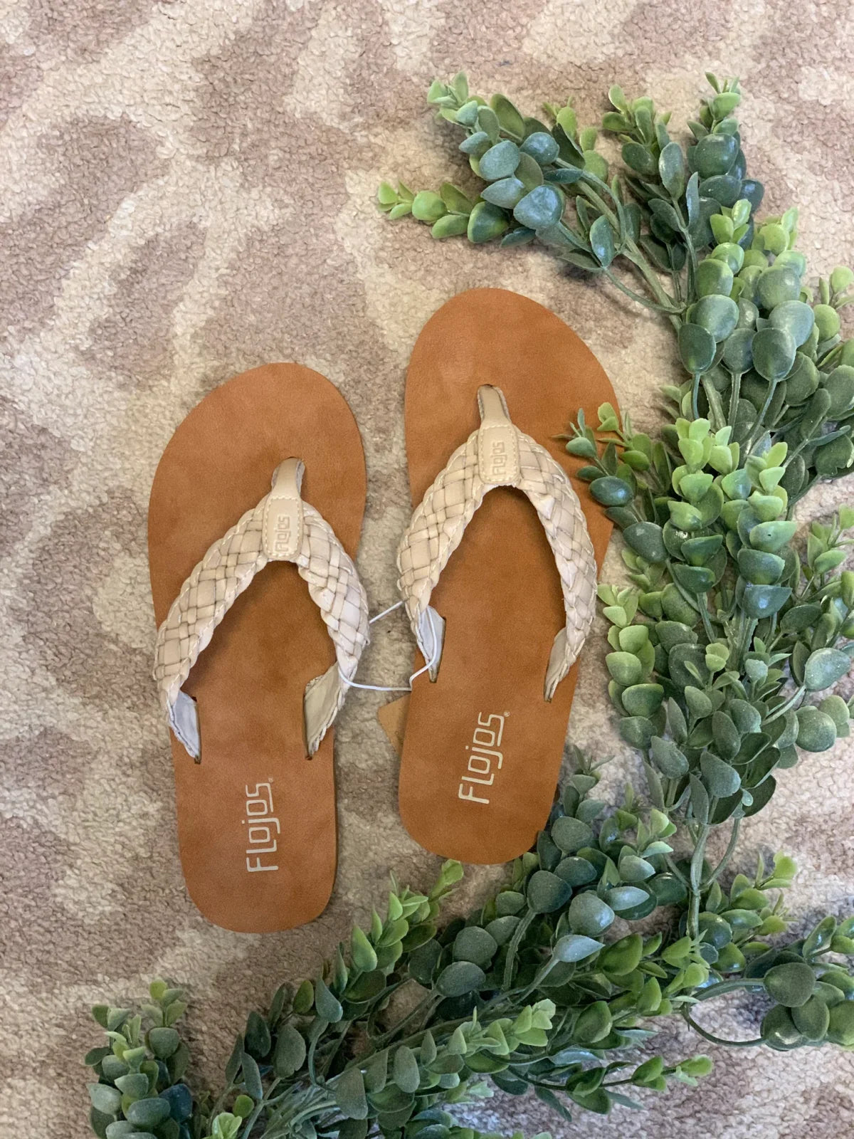 Ilse Jacobsen braided flip flops styled with greenery, perfect for a coastal boutique clothing collection.