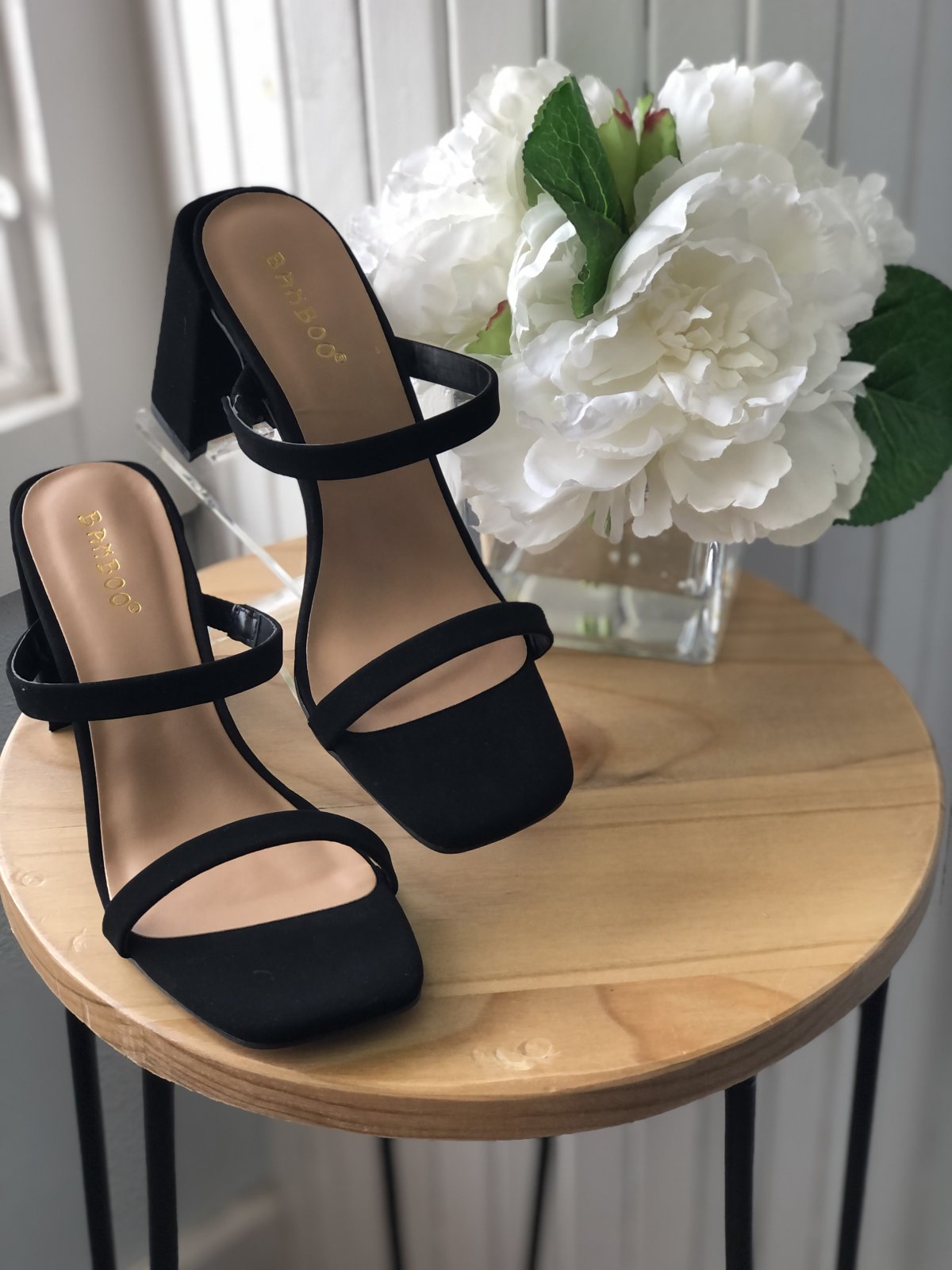 BLACK KICKBACK HEEL on display with white flowers, perfect for trendy coastal style at Raggdoll Boutique, Port Aransas.