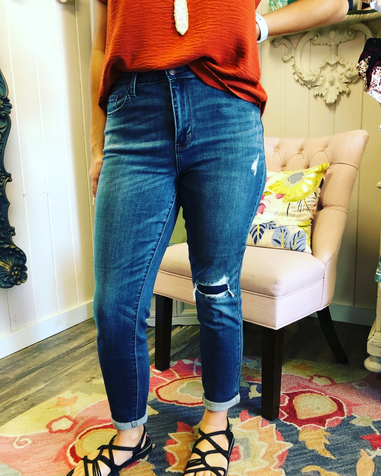 Woman wearing JUDY BLUE BOYFRIEND DESTROYED KNEE PATCH JEANS, styled with trendy coastal fashion from Raggdoll Boutique.