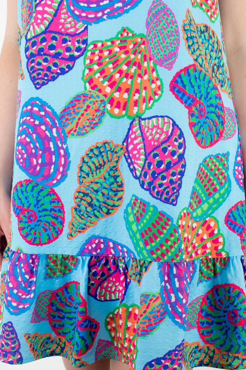 Vibrant shell print dress with ruffle hem, perfect for coastal boutique clothing and summer beach fashion.