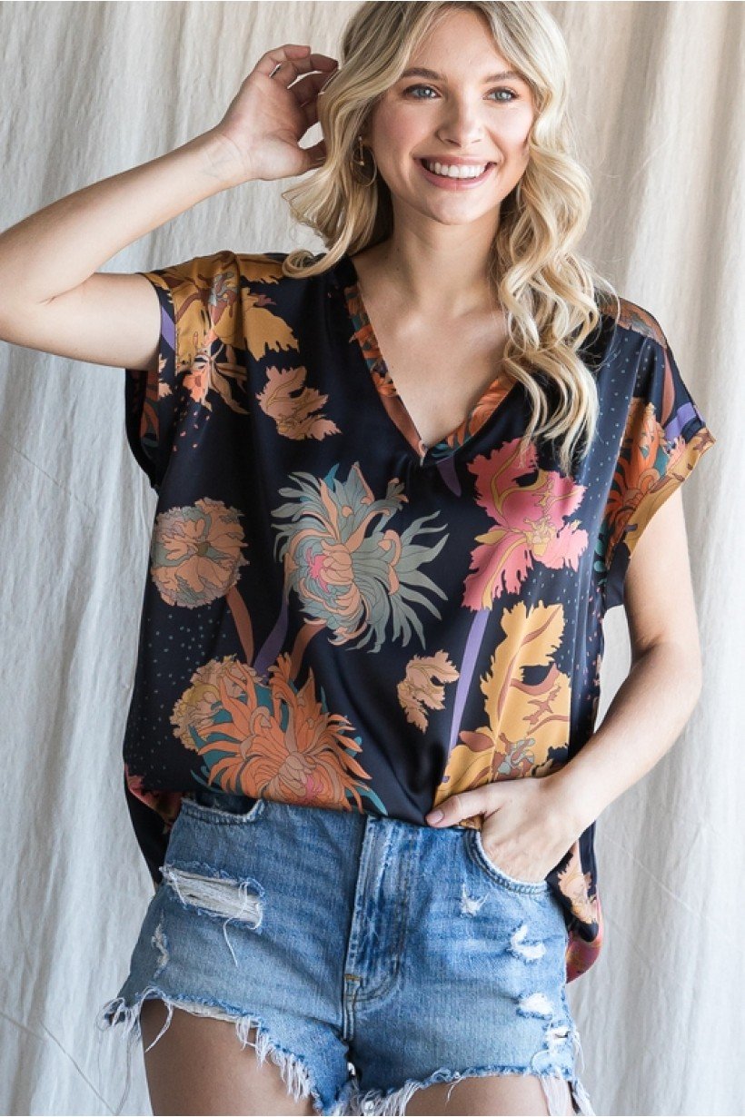 Model wearing BLACK SATIN PRINT TOP with floral design, perfect for coastal fashion at Raggdoll Boutique.