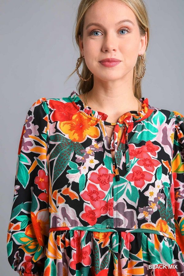 Woman wearing a vibrant FLOWER POWER DRESS from Raggdoll Boutique showing trendy coastal style.
