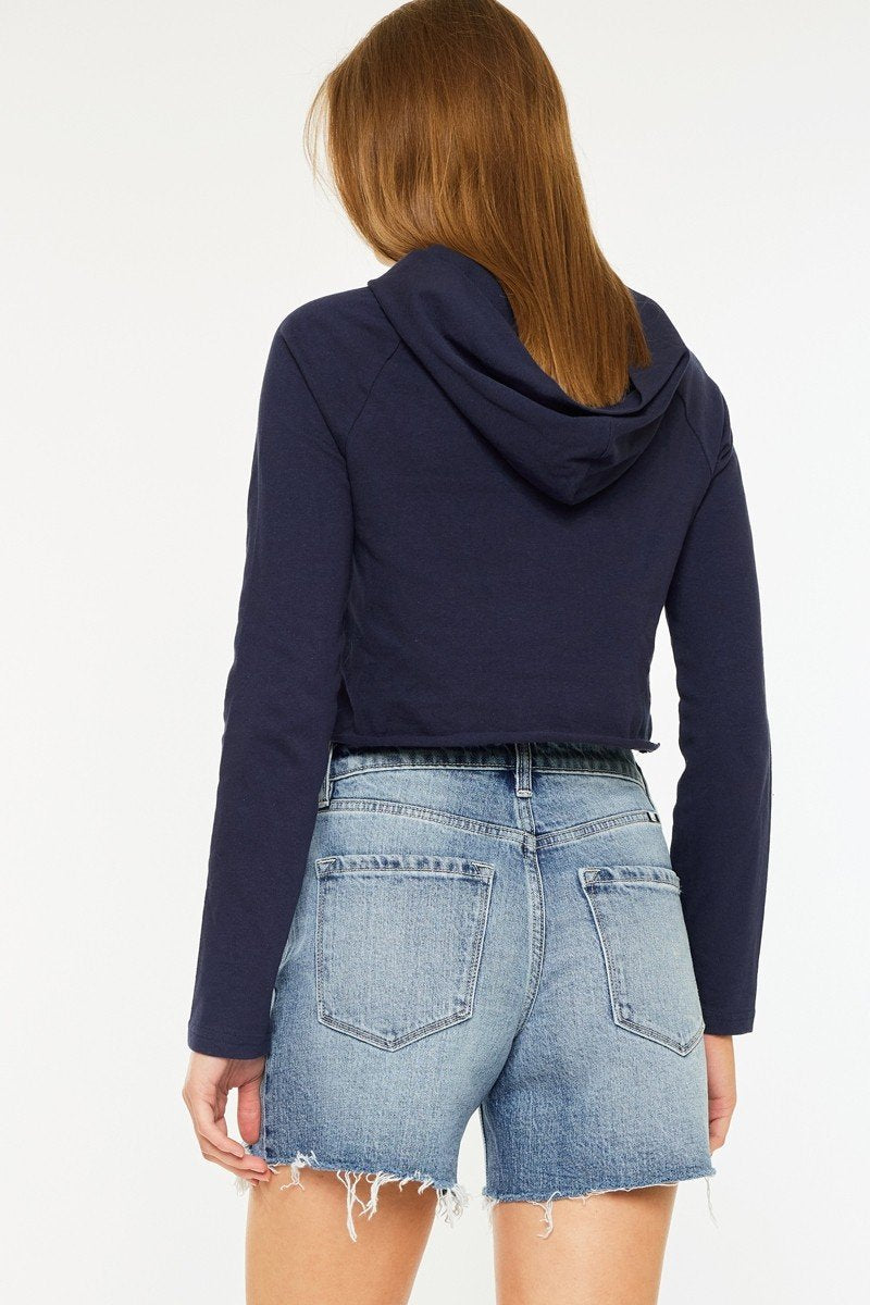 Model wearing Milo Shorts with a cropped navy hoodie, showcasing a casual summer outfit for coastal boutique clothing.