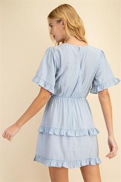 Woman wearing a SKY BLUE DRESS with ruffled sleeves, perfect for coastal fashion at Raggdoll Boutique.