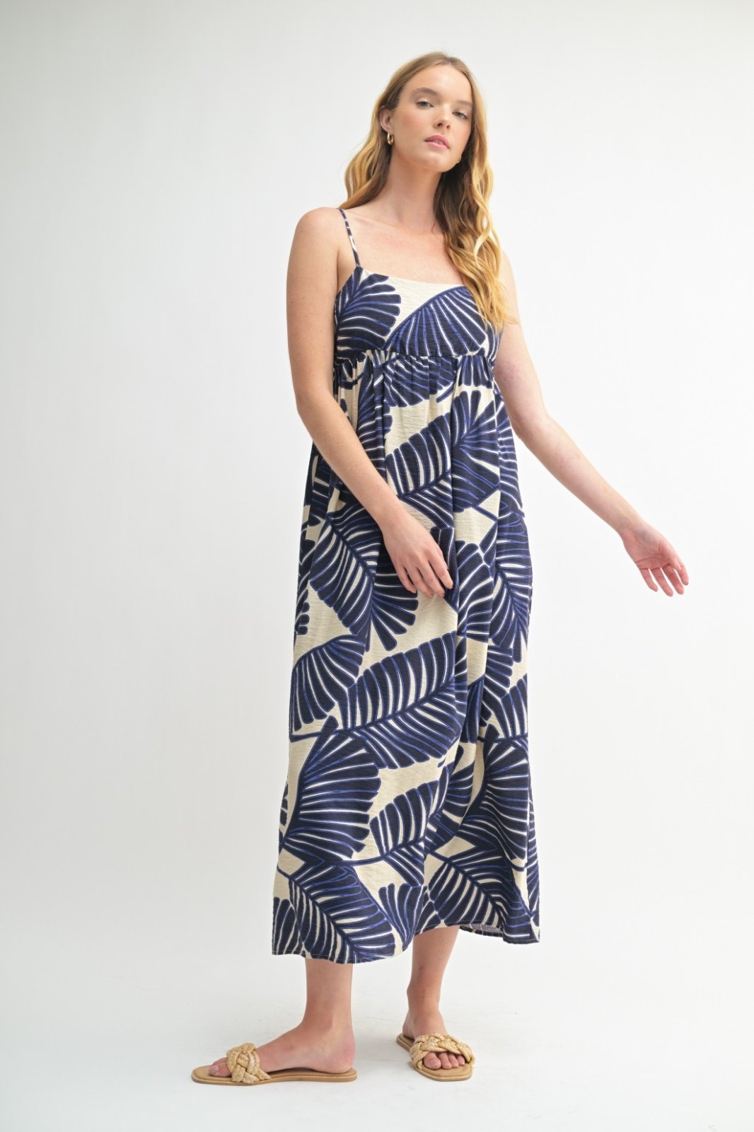 Blue and cream spaghetti strap maxi dress with leaf print, perfect for beach outings and summer events, from a coastal boutique.