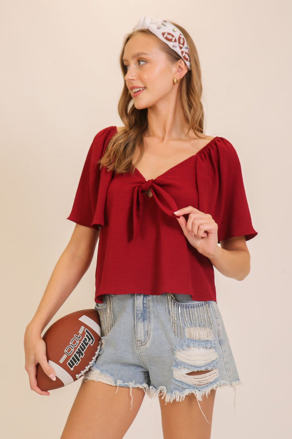 Stylish maroon game day top paired with denim shorts, perfect for coastal boutique clothing and tropical vacation dresses.