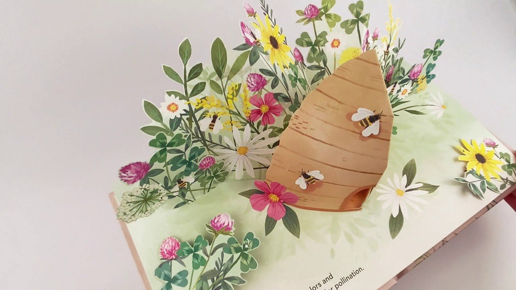 FLORA BOTANICAL POP-UP BOOK showcasing vibrant flowers and bees in a beautifully designed pop-up scene.