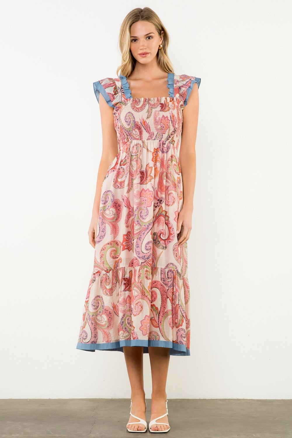 Molly Dress from a coastal boutique, perfect for tropical vacations, featuring vibrant paisley print and stylish ruffled sleeves.