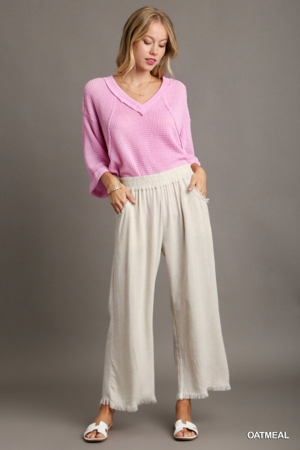 Model in pink top and OATMEAL FRAYED HEM PANT-UMGEE, showcasing trendy coastal style at Raggdoll Boutique.