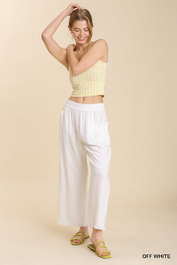 Woman wearing WHITE FRAYED HEM PANT paired with a yellow checked top, showcasing trendy coastal style from Raggdoll Boutique.