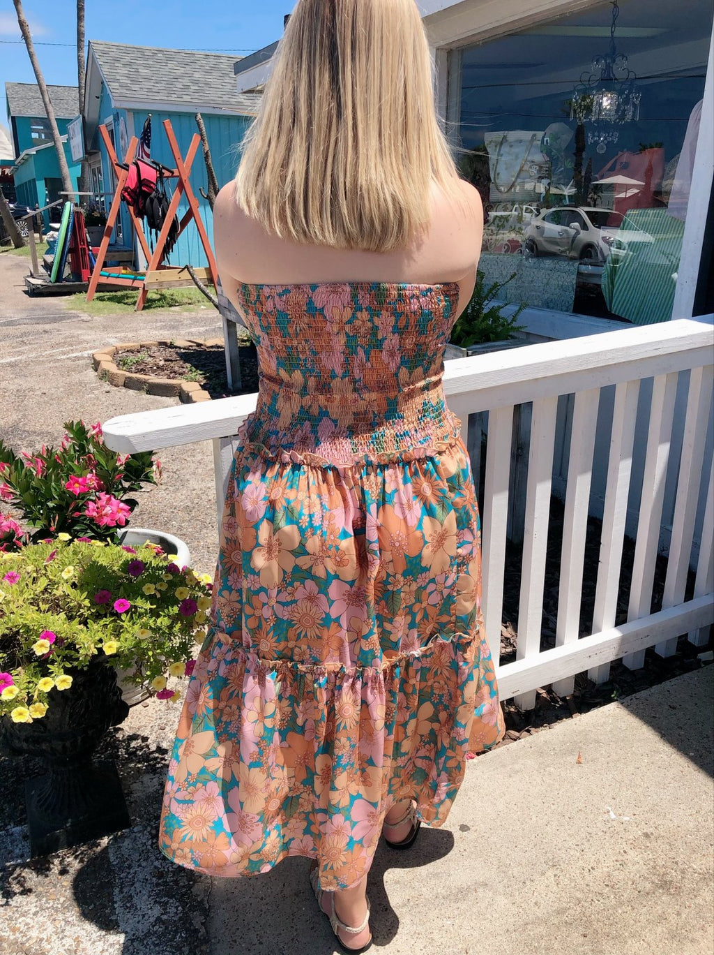 Woman wearing the OH, FLOWERS! SMOCKED TOP MIDI DRESS at a coastal boutique, showcasing trendy summer fashion.