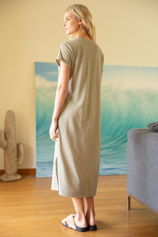 Back view of a woman wearing the COMFY OLIVE DRESS from Raggdoll Boutique, showcasing its midi length and side slit.