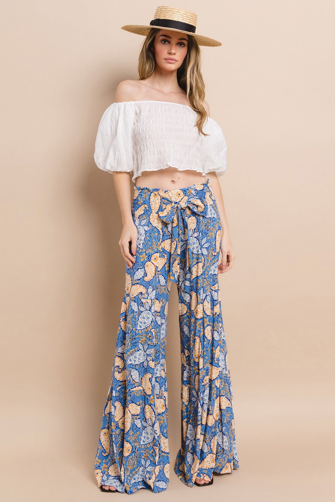 Blue paisley print palazzo pants paired with a white off-shoulder top, perfect for coastal boutique clothing and beach vibes.
