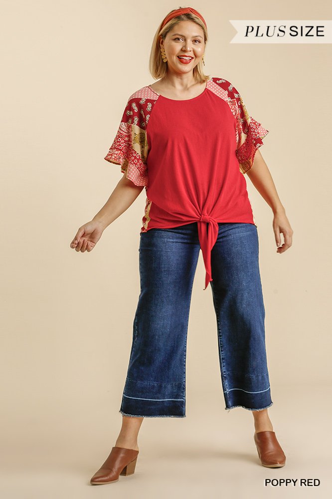 Woman wearing Poppy Top Plus with colorful sleeves, paired with jeans, showcasing trendy coastal style from Raggdoll Boutique.