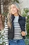 Stylish woman in a black vest with bow detail, perfect for coastal boutique clothing and curated women's fashion.