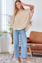 Model wearing CHAMPAGNE BUTTON-UP TOP with blue jeans, showcasing trendy coastal style from Raggdoll Boutique.