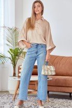 Woman in a beige CHAMPAGNE BUTTON-UP TOP with stylish wide-leg jeans, showcasing trendy coastal style for summer outfits Texas.