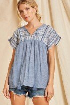 Model wearing DENIM/WHITE EMBROIDERED TOP from Raggdoll Boutique, showcasing trendy coastal style.