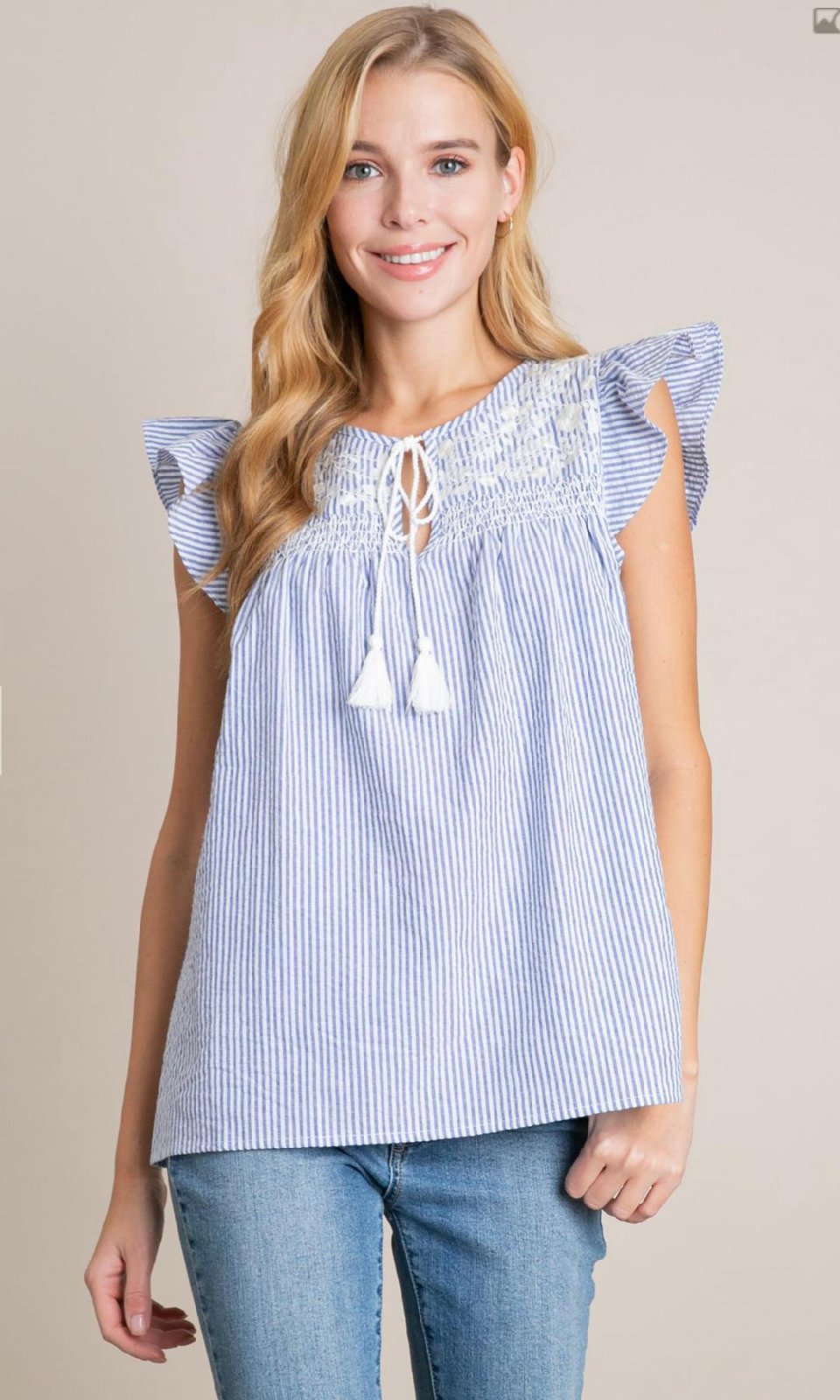 Blue and white seersucker embroidered top, perfect for coastal boutique clothing and beach dresses, ideal for tropical vacations.