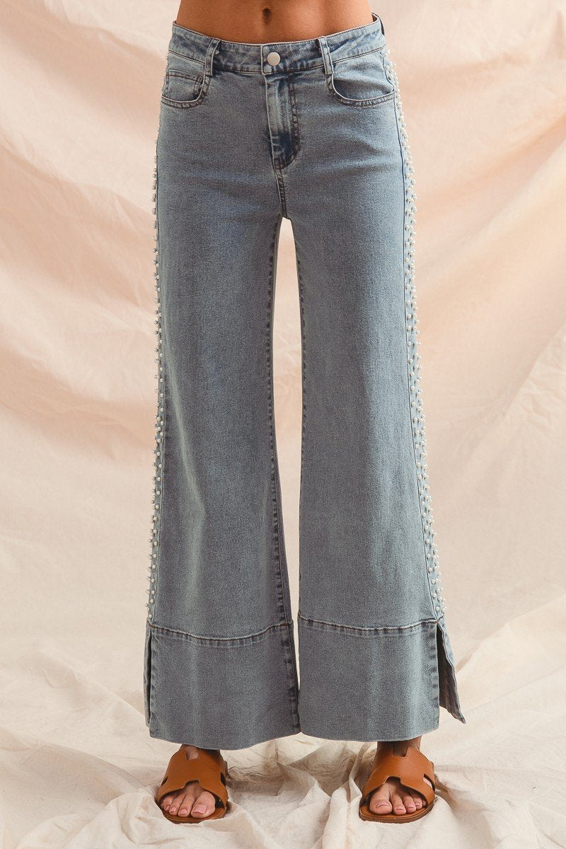 Stylish women's wide-leg jeans with side slits, perfect for a coastal boutique clothing collection, great for beach days.