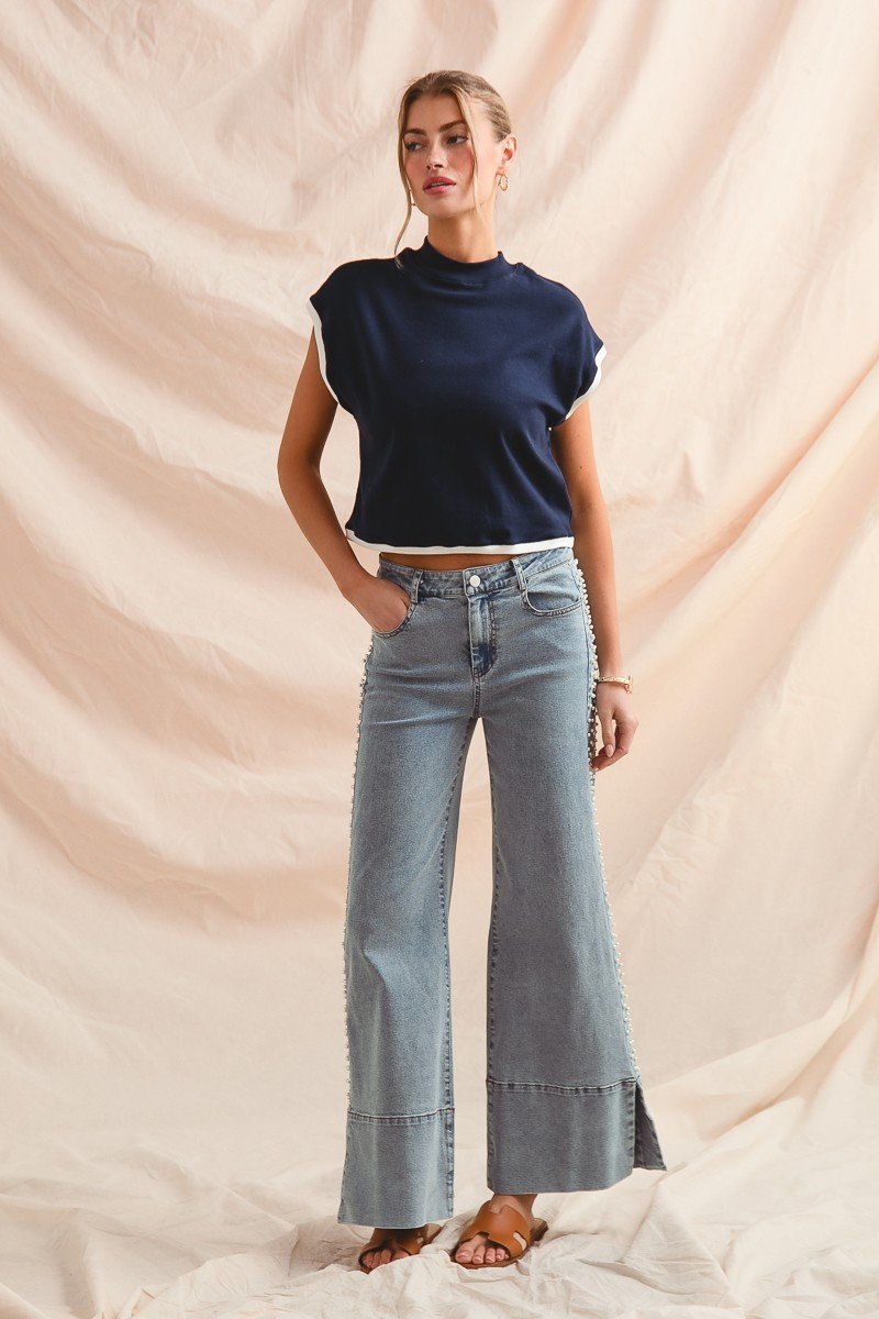 Model wearing Tullah Jeans with a stylish navy top, showcasing coastal boutique clothing and modern flare denim.