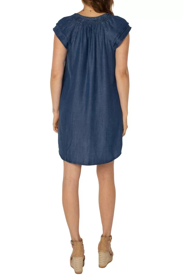 Woman wearing LIVERPOOL VAN NUYS DENIM DRESS with a hi-low hem, perfect for trendy coastal style at Raggdoll Boutique.