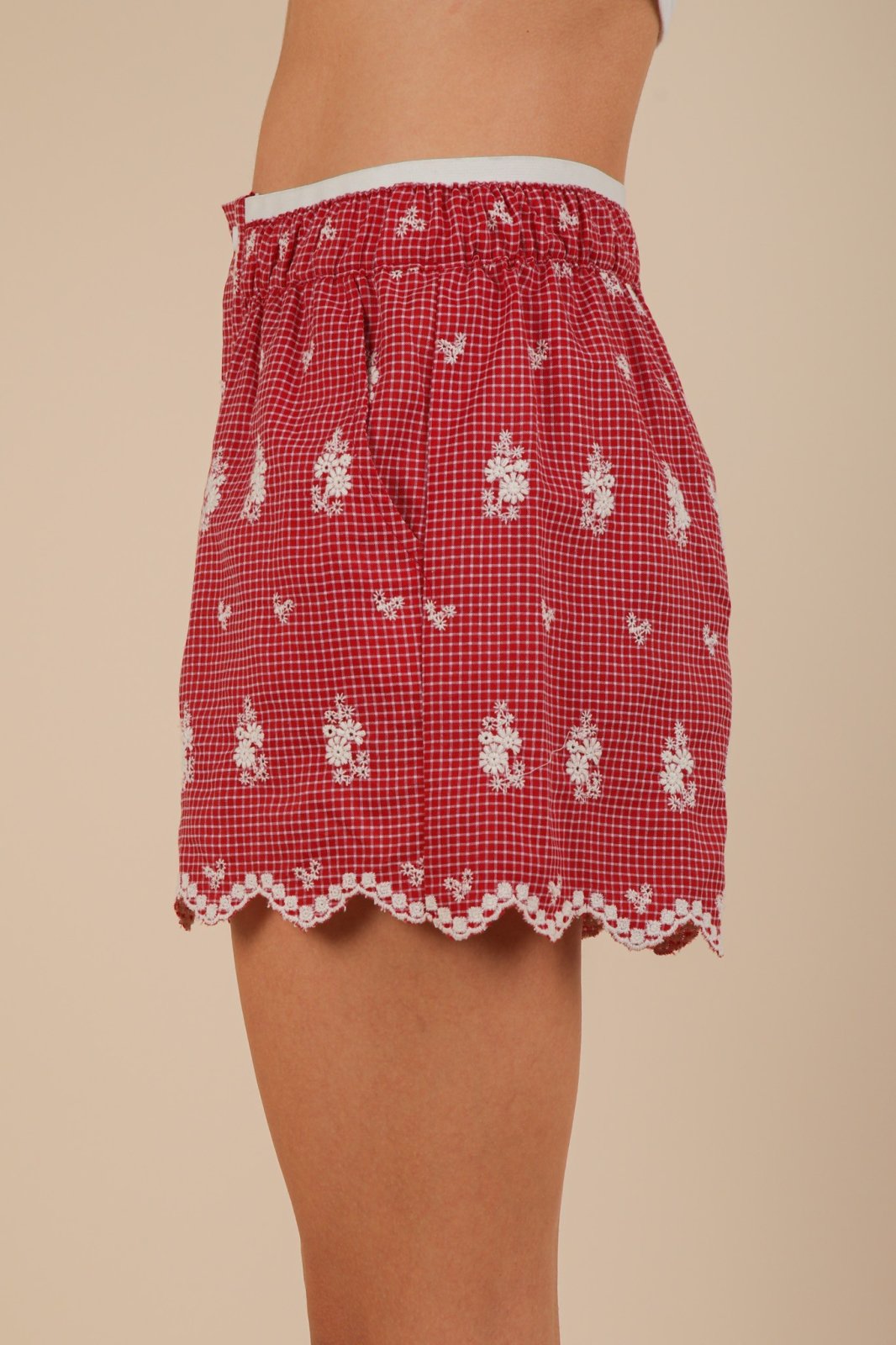 Stylish red Sami shorts with delicate embroidery, scalloped hem, and elastic waistband, perfect for coastal boutique fashion.