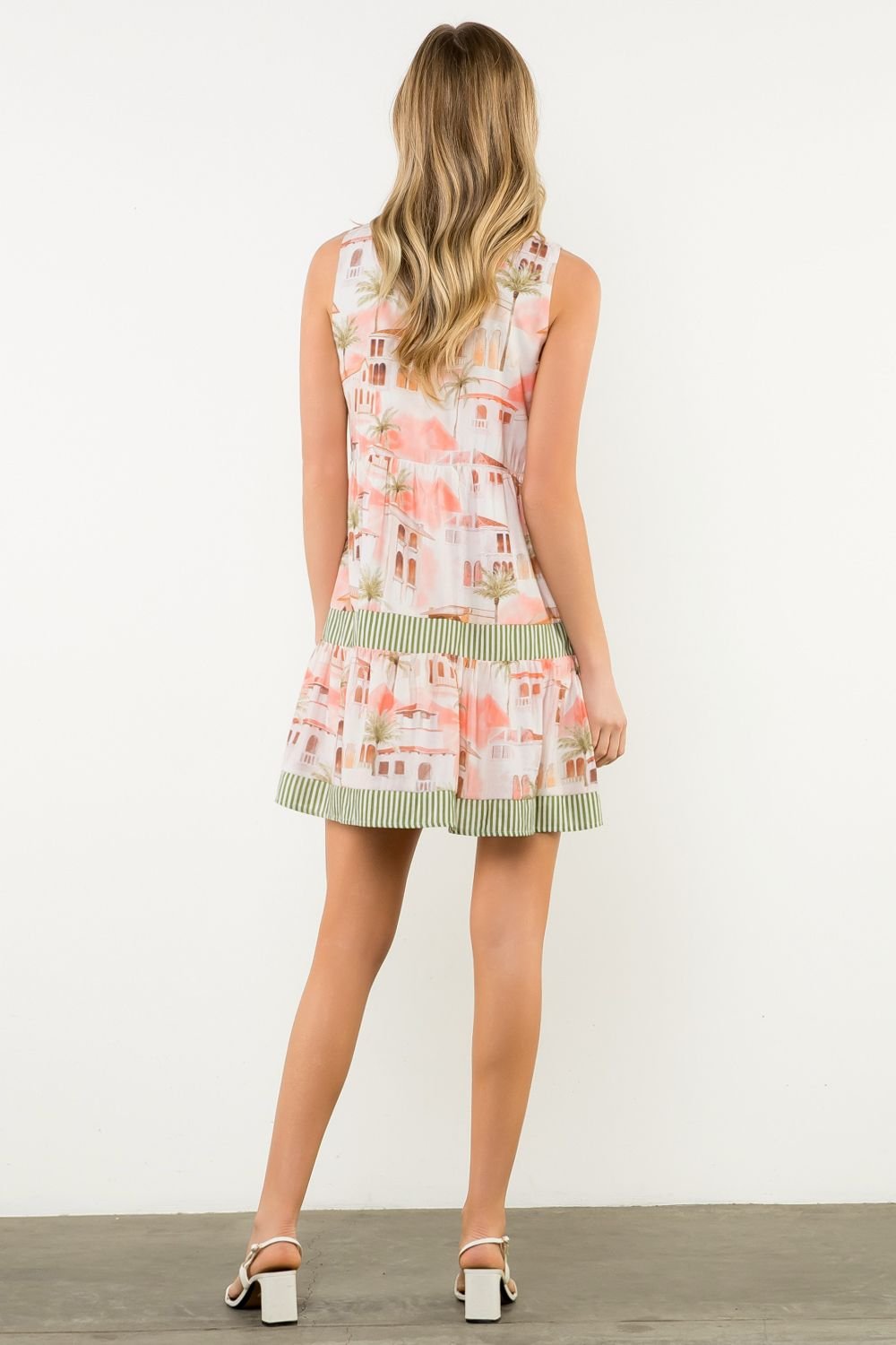 Girl modeling Isla Dress with soft cream & sage stripes, perfect for coastal boutique clothing & tropical vacation dresses.