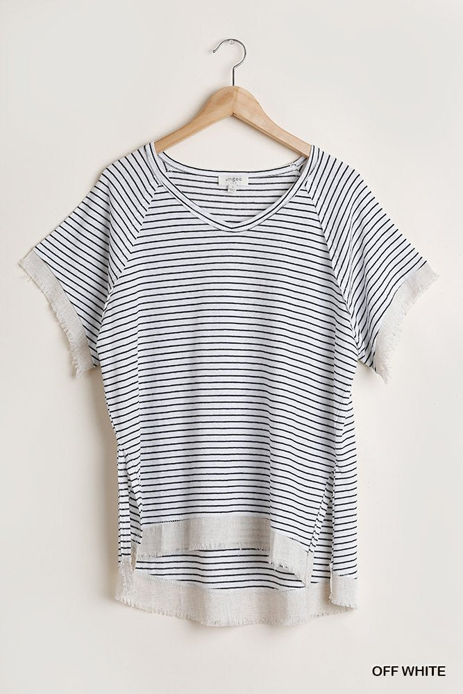 WHITE AND BLACK STRIPED TOP WITH RAW EDGE DETAIL hanging on a wooden hanger, perfect for summer outfits Texas.