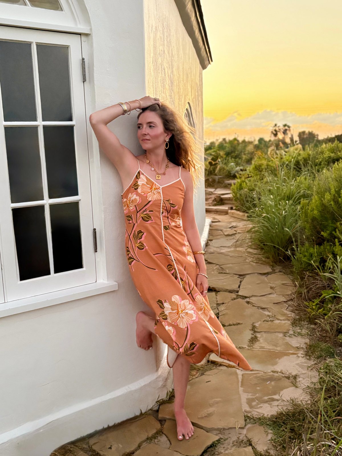 Woman wearing a peach floral dress at sunset